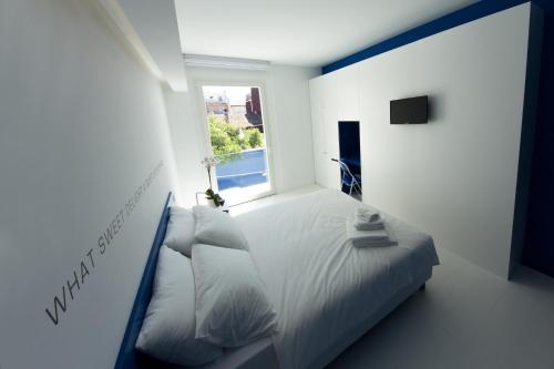 Habitación blanca con cama y ventana en Bed 'n Design, en Floridia