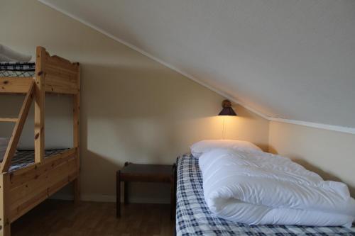 a bedroom with a bunk bed and a ladder at Camp Åpta in Farsund