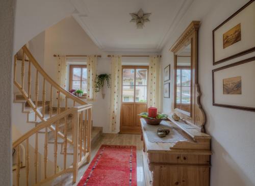 a hallway with a staircase and a red rug at Landhaus Johannes in Mayrhofen