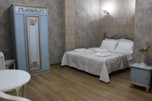 a bedroom with a bed with two towels on it at Borjomi Classic Hotel in Borjomi