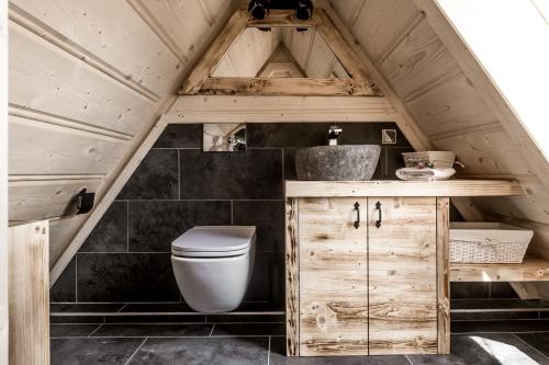 an attic bathroom with a toilet and a sink at TatryTop Osada Luxury Chalets Kościelisko in Kościelisko