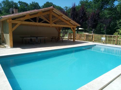- une piscine avec un pavillon et une table de pique-nique dans l'établissement Les pruniers de la cipière, à Peyzac-le-Moustier