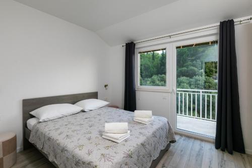 um quarto com uma cama e uma grande janela em Relax Zone Apartment em Trsteno