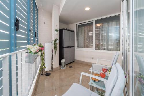 a balcony with a chair and a table with flowers at Apartment Arianna in Zadar