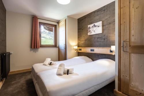 two white beds in a room with a window at Résidence Daria-I Nor by les Etincelles in L'Alpe-d'Huez
