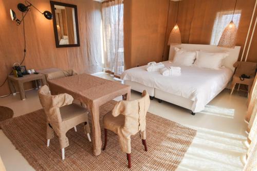 a bedroom with a bed and a table and chairs at Hotel The Exchange in Amsterdam