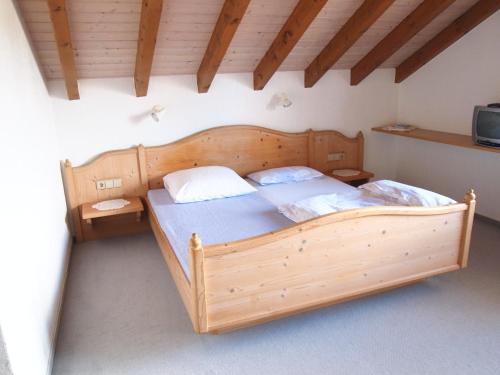 ein Schlafzimmer mit einem großen Holzbett in einem Zimmer in der Unterkunft Gästehaus Hirlinger in Burladingen