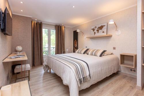 Dormitorio con cama, escritorio y TV en Villa Les Quatre Vents en La Baule