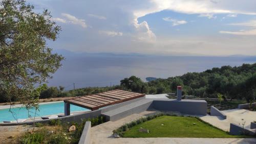 a house with a swimming pool and a view of the ocean at Gems of Pinakates in Pinakátai