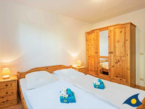 Un dormitorio con dos camas con toallas azules. en Villa Maria Gabriele Whg 02, en Stubbenfelde
