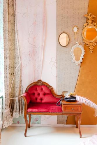a red couch in a room with a mirror at Hotel The Exchange in Amsterdam