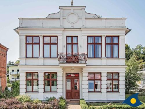 Una casa blanca con un reloj encima. en Villa an der Post Whg 02, en Heringsdorf