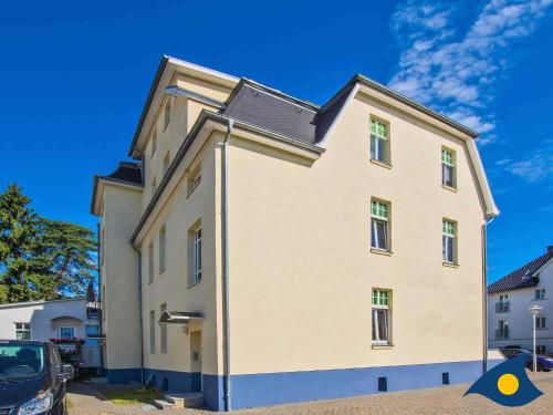 ein großes weißes Gebäude mit einem schwarzen Dach in der Unterkunft Villa Malve Wohnung 05 in Bansin