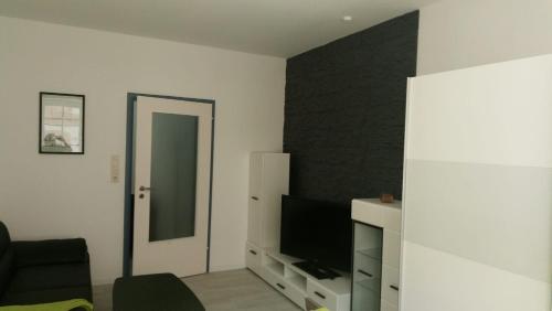 een woonkamer met een tv en een zwarte muur bij City Apartments Ebern in Ebern