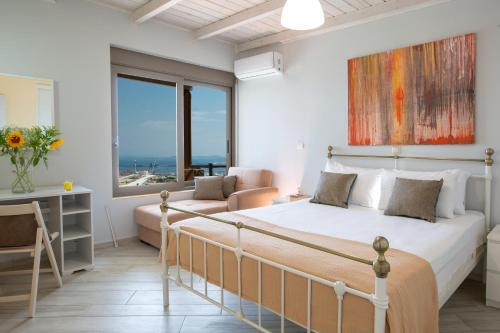 ein Schlafzimmer mit einem Bett und einem Sofa in der Unterkunft Silencio Villas in Lefkada Town