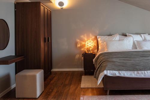a bedroom with a bed and a lamp on a night stand at Boutique Hotel Boškinac in Novalja