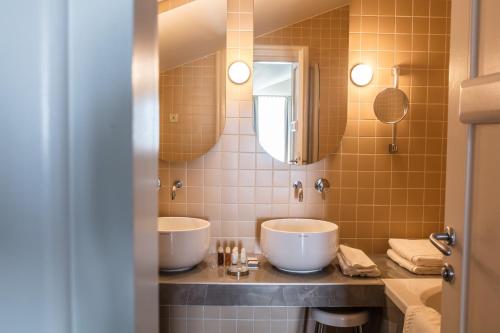 a bathroom with two sinks and a mirror at Boutique Hotel Boškinac in Novalja