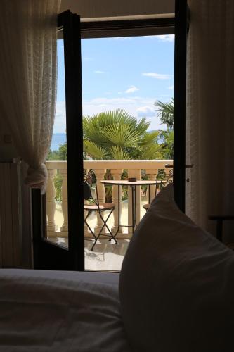 a bedroom with a bed and a view of a balcony at VILLA ANA LOVRAN apartments & rooms in Lovran