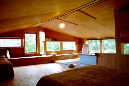 a bedroom with a bed and a couch and windows at Chambres d'hôtes des Forges in Cellefrouin