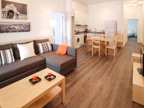 sala de estar y cocina con sofá y mesa en City Stays Cais do Sodre Apartments, en Lisboa