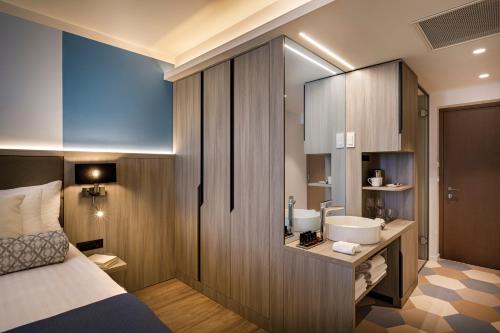 a small bathroom with a sink and a bed at Valamar Carolina Hotel & Villas in Rab