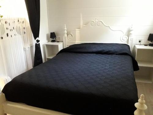 ブルリ・シュル・メールにあるChristineのベッドルーム1室(黒い掛け布団付きのベッド1台付)