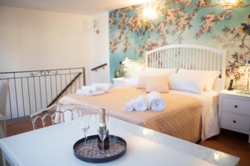 1 dormitorio con 1 cama con toallas y copa de vino en Bed Boutique Napoli Colors, en Nápoles