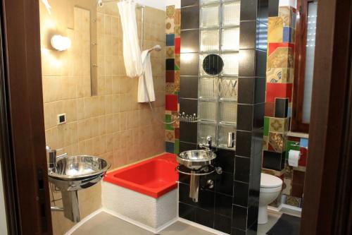 a bathroom with a red sink and a toilet at apdf appartamento con giardino in San Salvo