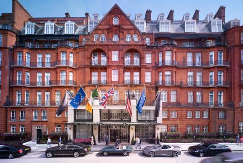 a large red brick building with cars parked in front of it at Claridge's in London