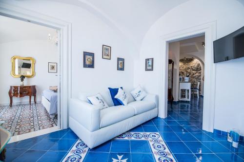 a living room with a white couch and blue tile floors at Suite Picasso in Amalfi