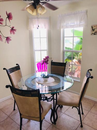 a dining room with a glass table and chairs at Robin's Nest in Orlando