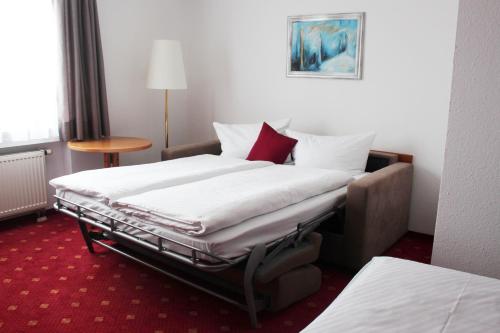 a hotel room with two beds and a table at Hotel Gasthof Adler in Ulm