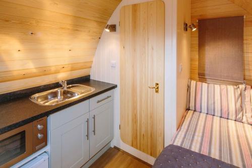 een kleine keuken met een wastafel en een aanrecht bij Willowherb Glamping Pod in Cheltenham