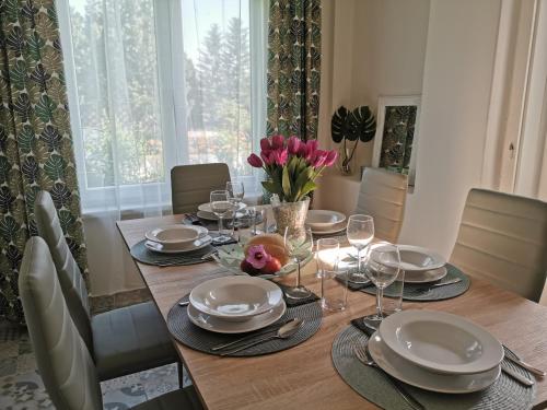 una mesa de comedor con platos y copas de vino en Villa Vonyarc, en Vonyarcvashegy