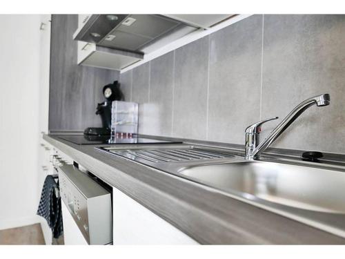 a stainless steel kitchen with a sink and a stove at Speedys Gästehaus am Brünnchen in Herresbach