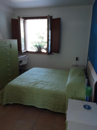 a bedroom with a green bed and a window at Fonte la Perna in Polverigi