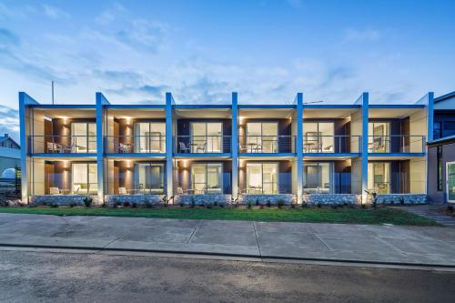 um edifício de apartamentos com colunas azuis numa rua em Aurora Ozone Hotel Kangaroo Island em Kingscote