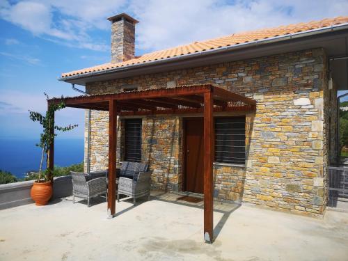 a patio with two chairs and a brick building at Gems of Pinakates in Pinakátai