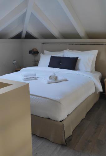 a large white bed with two towels on it at Gems of Pinakates in Pinakátai