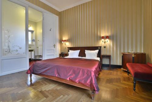 a bedroom with a large bed with a red blanket at Gerlóczy Boutique Hotel in Budapest