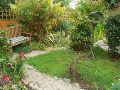 a garden with a bench and a gazebo at Trelawney Guest House Room only in Falmouth