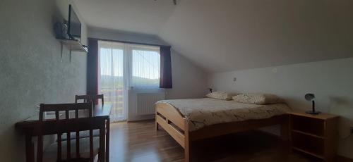 a bedroom with a bed and a large window at Rooms Jure Sabljak in Grabovac