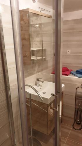 a bathroom with a sink and a shower at Apartmani Slavica in Rab