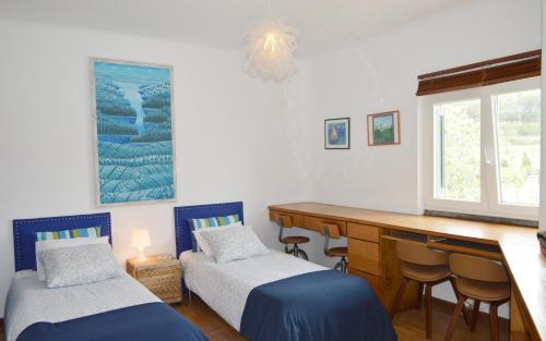 a room with two beds and a desk and a window at Morada Sol - Holiday Villas in Cascais in Cascais