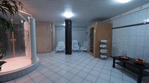 a bathroom with a tub and chairs and a table at Hotel Gasthof Adler in Ulm