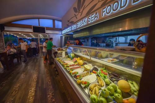 a restaurant with a buffet of food in a store at Belcehan Hotel in Oludeniz