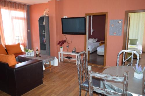 a living room with a couch and a tv at Morska Zvezda Guest house in Pomorie