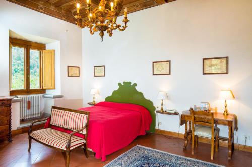 a bedroom with a red bed and a table and chairs at Villa Pitiana in Donnini