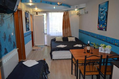 a room with a table and a bed and a dining room at Morska Zvezda Guest house in Pomorie