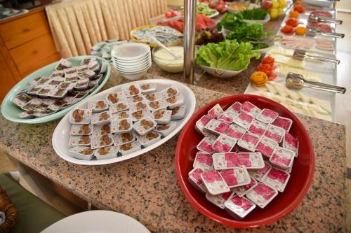 a table with plates of food on a counter at Belcehan Hotel in Oludeniz